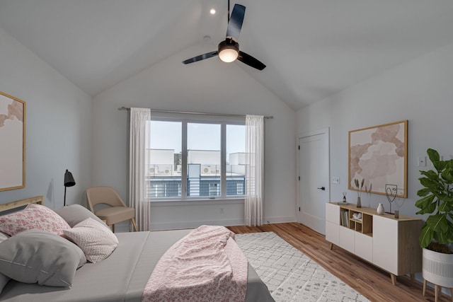 bedroom with ceiling fan, light hardwood / wood-style flooring, and vaulted ceiling