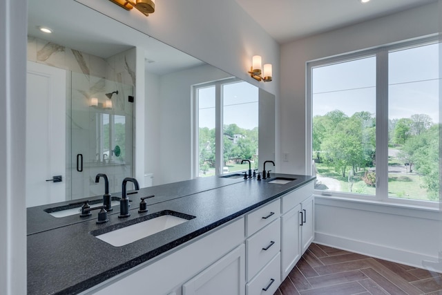 bathroom featuring vanity, a healthy amount of sunlight, and walk in shower