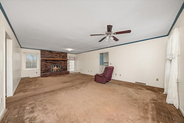 unfurnished living room with carpet, a fireplace, ceiling fan, and a textured ceiling