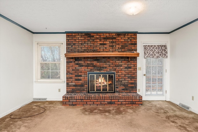 unfurnished living room with carpet flooring, a textured ceiling, a fireplace, and crown molding