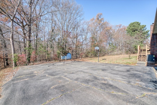 view of patio featuring a shed, central AC unit, and basketball hoop