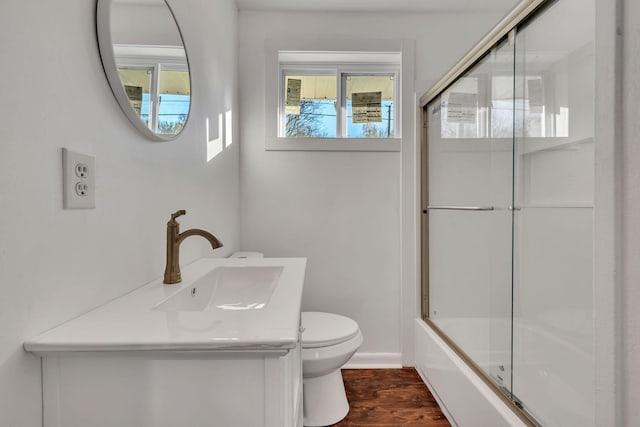 full bathroom featuring shower / bath combination with glass door, hardwood / wood-style floors, toilet, and plenty of natural light