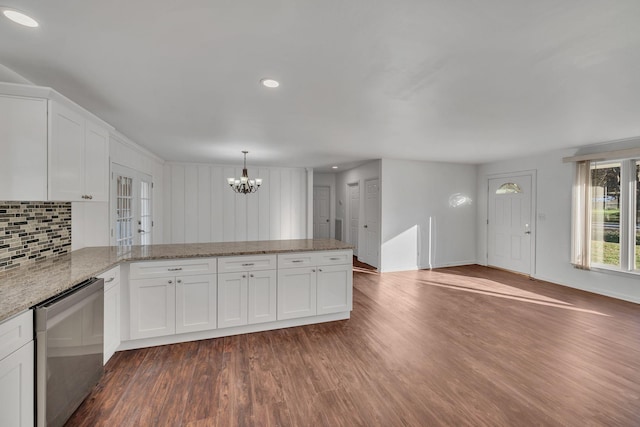 kitchen featuring white cabinetry, hanging light fixtures, dark wood-type flooring, a notable chandelier, and backsplash