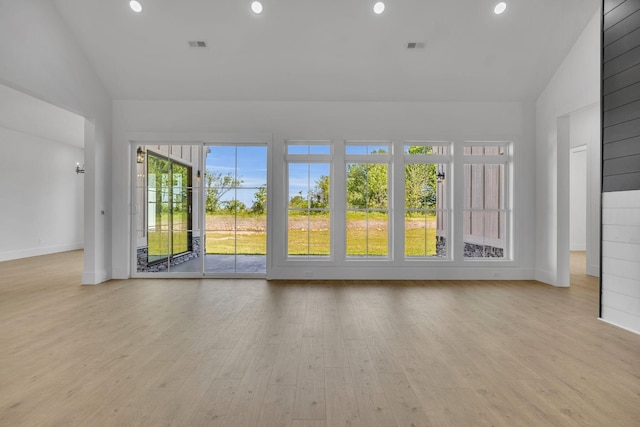 unfurnished room featuring light wood-type flooring and lofted ceiling