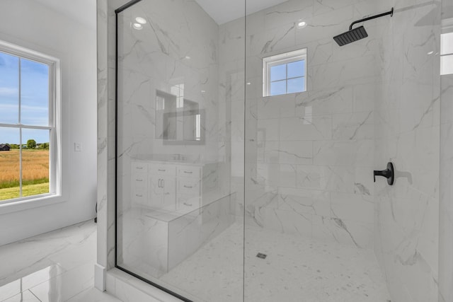 bathroom with a shower with shower door and a healthy amount of sunlight