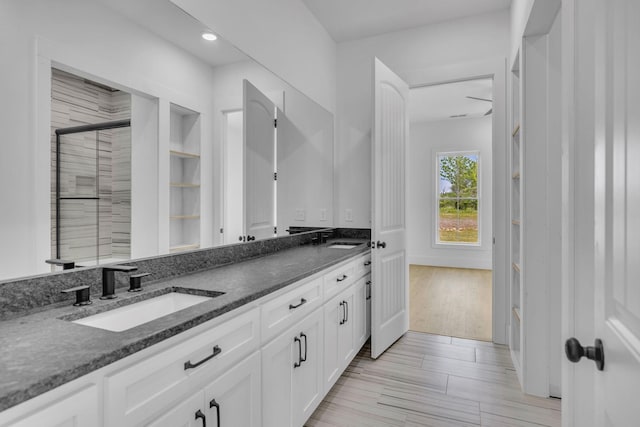 bathroom with vanity, hardwood / wood-style flooring, and a shower with door