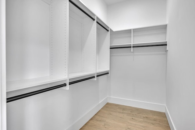 walk in closet with light hardwood / wood-style floors