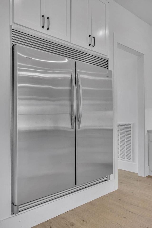 details with light wood-type flooring, white cabinetry, and built in refrigerator