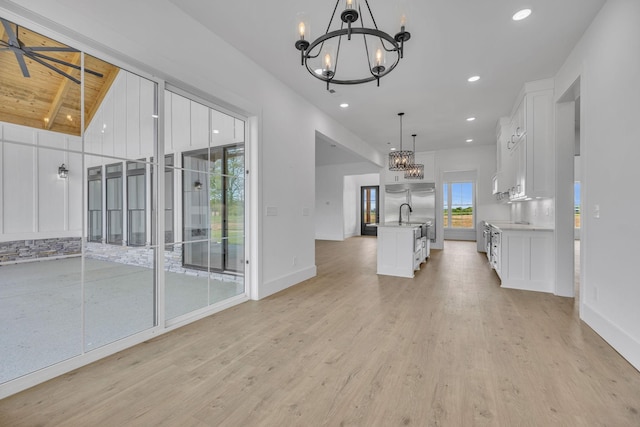 interior space with vaulted ceiling with beams, a chandelier, light hardwood / wood-style floors, and wooden ceiling