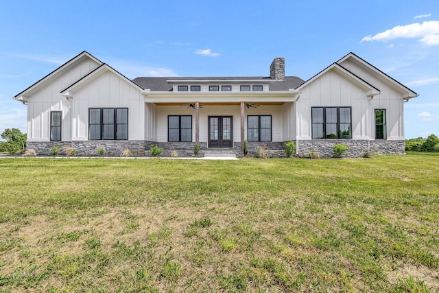 view of front of home featuring ceiling fan, french doors, and a front lawn