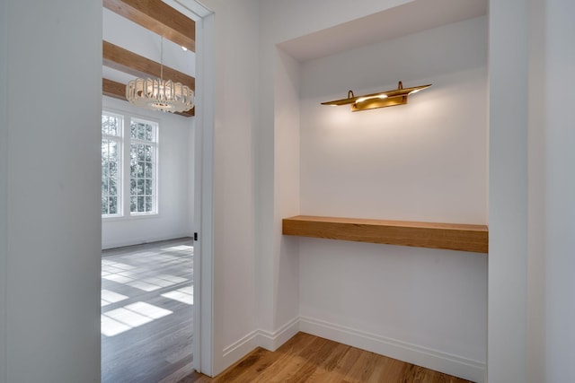 corridor featuring a notable chandelier and light hardwood / wood-style floors