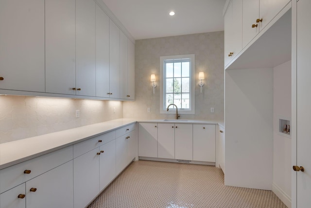 kitchen with white cabinetry, sink, and backsplash