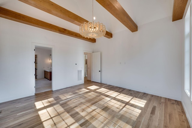 empty room with beamed ceiling, light hardwood / wood-style flooring, and a notable chandelier