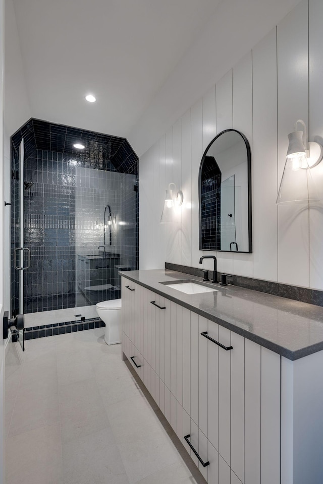 bathroom with a shower with door, vanity, tile patterned flooring, and toilet