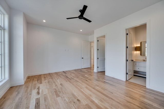 unfurnished bedroom with multiple windows, light hardwood / wood-style flooring, and ensuite bathroom