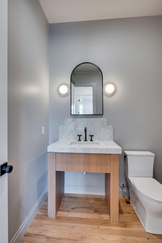 bathroom featuring sink, hardwood / wood-style flooring, and toilet