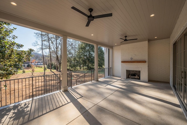 view of patio featuring an outdoor brick fireplace and ceiling fan