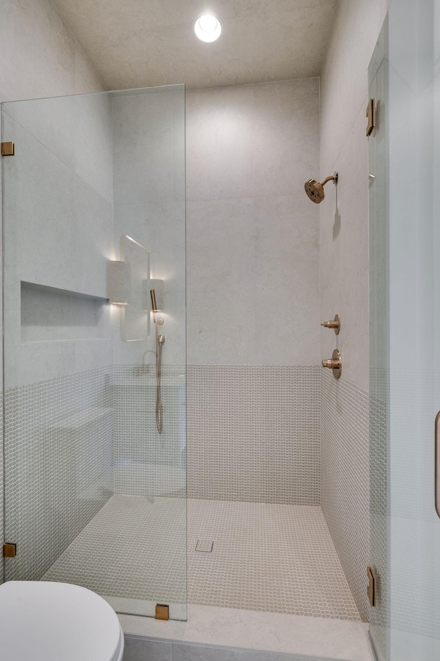 bathroom with an enclosed shower and toilet