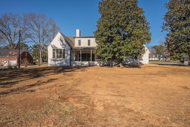 rear view of property with a lawn