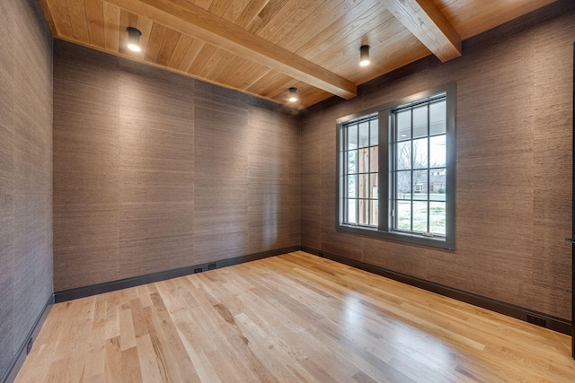 spare room featuring wooden ceiling, beamed ceiling, and light wood-type flooring