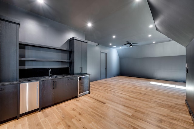 bonus room featuring vaulted ceiling, beverage cooler, ceiling fan, light hardwood / wood-style floors, and wet bar