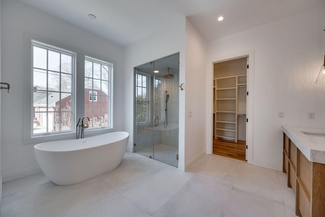 bathroom with vanity, separate shower and tub, and a wealth of natural light