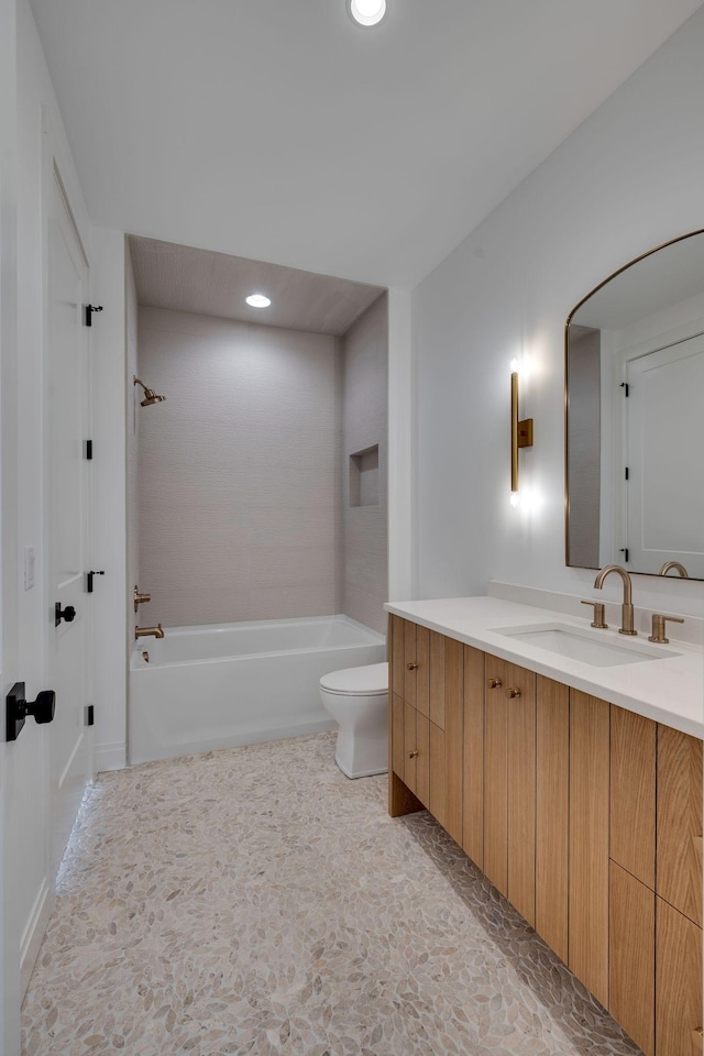 full bathroom with vanity, tiled shower / bath combo, and toilet