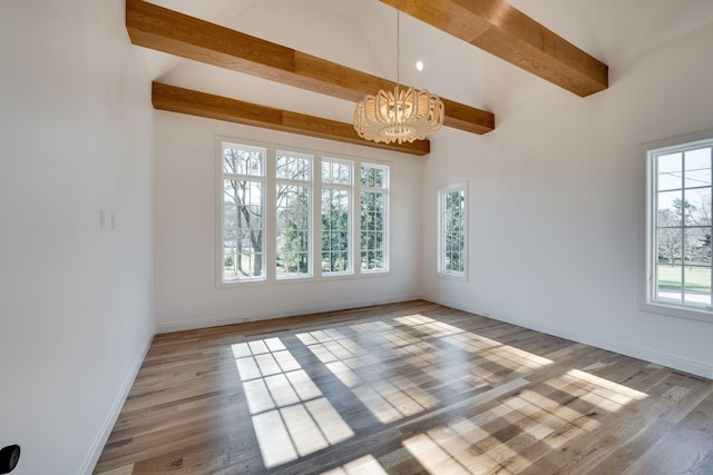 empty room featuring wood-type flooring, beamed ceiling, and a chandelier