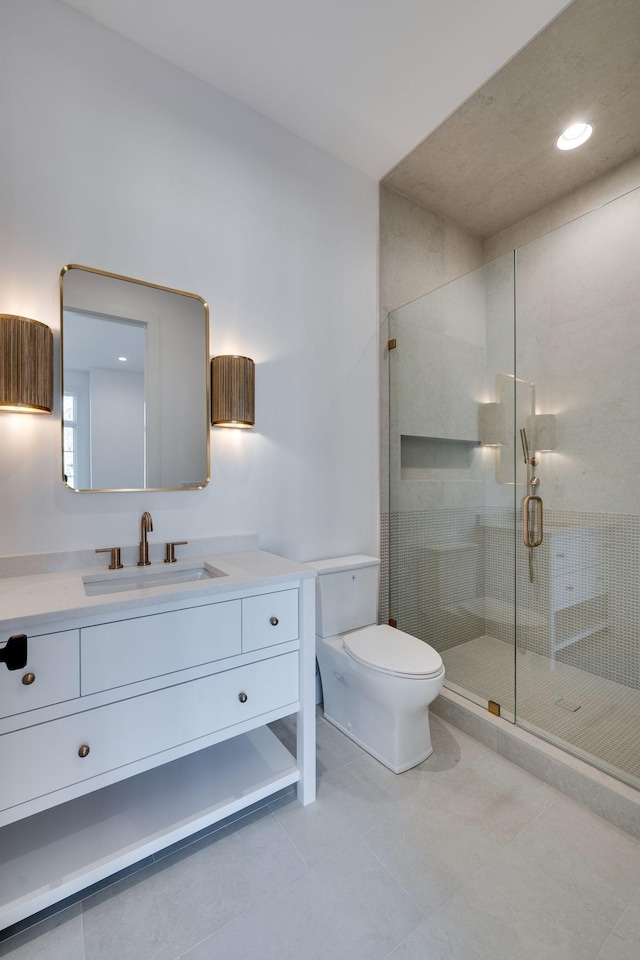 bathroom with vanity, a shower with shower door, tile patterned floors, and toilet