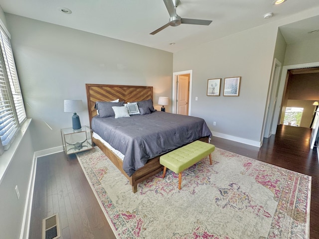 bedroom with multiple windows, dark wood-type flooring, and ceiling fan