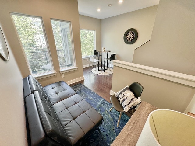 sitting room featuring dark wood-type flooring and a healthy amount of sunlight