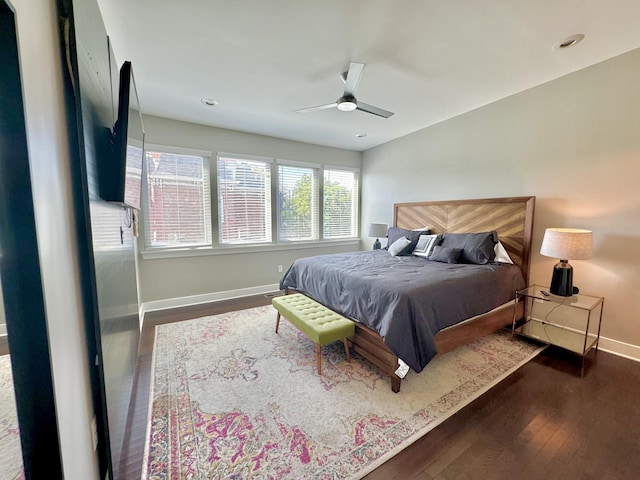 bedroom with dark hardwood / wood-style flooring and ceiling fan