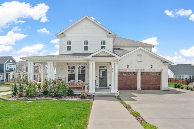 view of front of house with covered porch, a garage, and a front yard