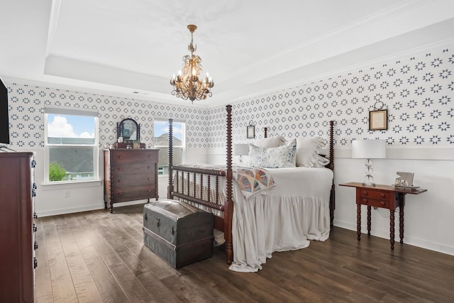 bedroom with a notable chandelier, dark hardwood / wood-style floors, a raised ceiling, and crown molding