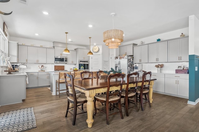 dining room with an inviting chandelier and dark wood-type flooring