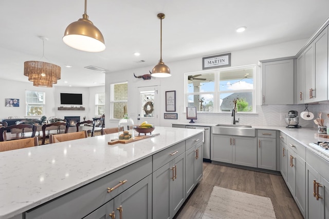 kitchen with decorative light fixtures, sink, and a wealth of natural light