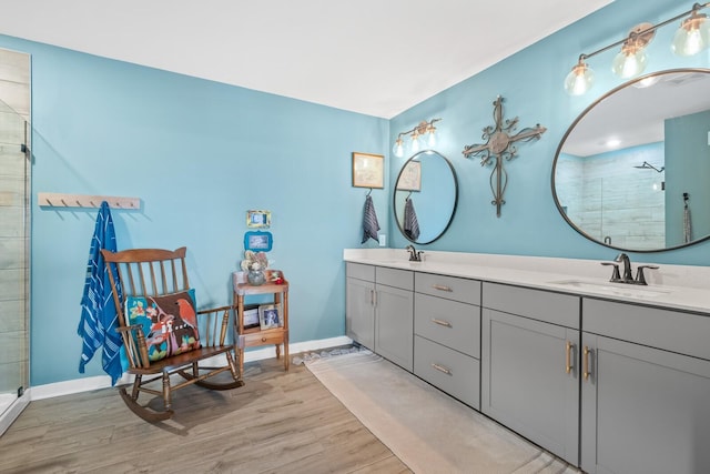 bathroom with hardwood / wood-style floors, vanity, and walk in shower