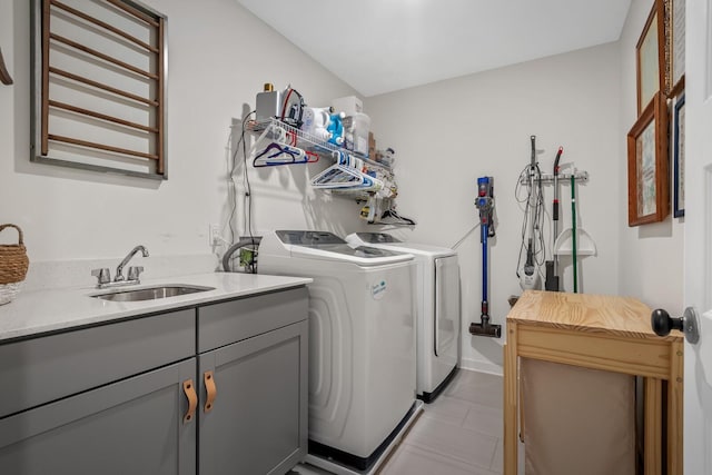 washroom with washing machine and dryer, sink, and cabinets