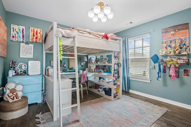 bedroom featuring wood-type flooring and a notable chandelier