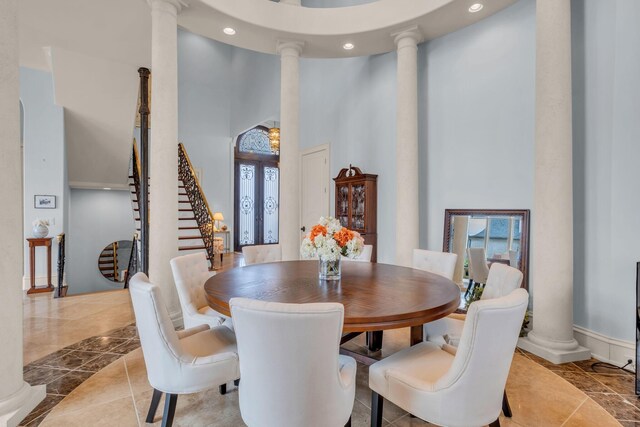 dining space with decorative columns and a towering ceiling