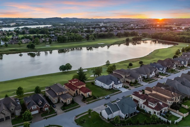 aerial view at dusk featuring a water view