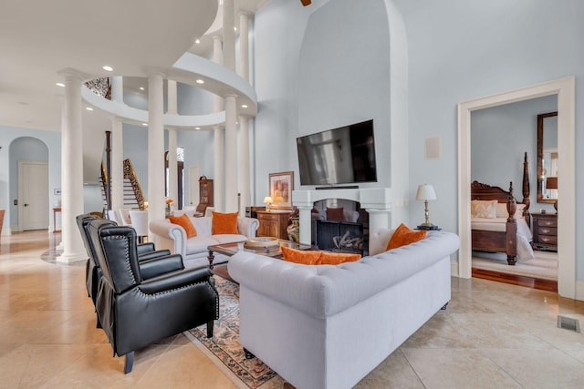 tiled living room with a high ceiling and decorative columns