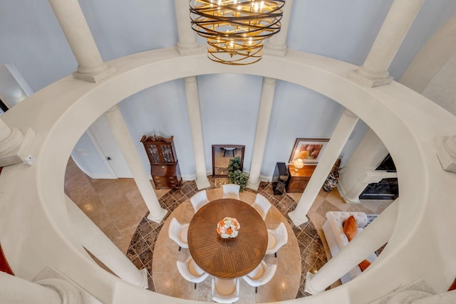 interior space featuring an inviting chandelier, ornate columns, and a towering ceiling