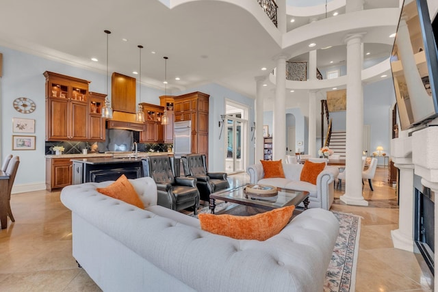 living room with sink, decorative columns, and a towering ceiling