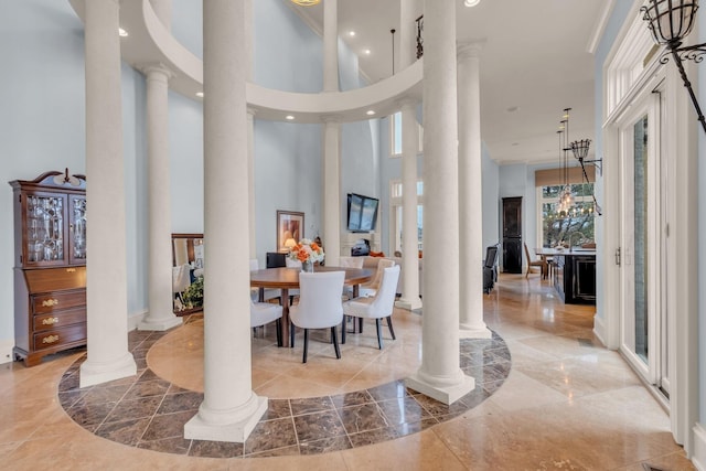 entrance foyer with ornate columns and a towering ceiling