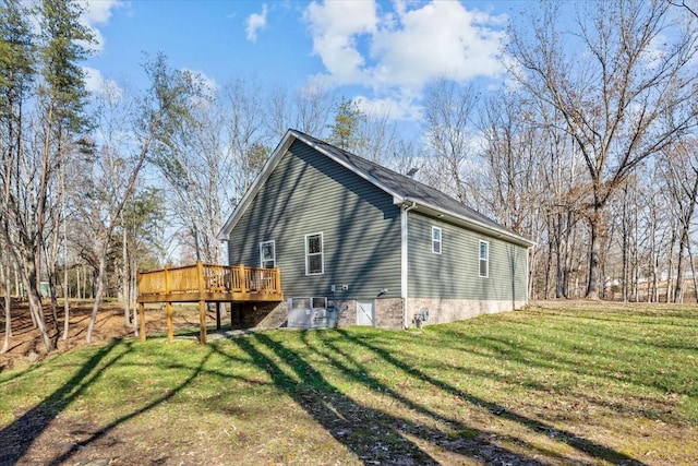 back of house featuring a deck and a lawn