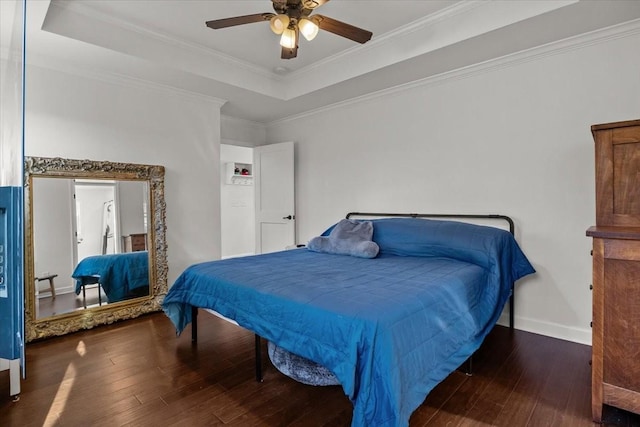 bedroom with hardwood / wood-style floors, ceiling fan, a raised ceiling, and crown molding