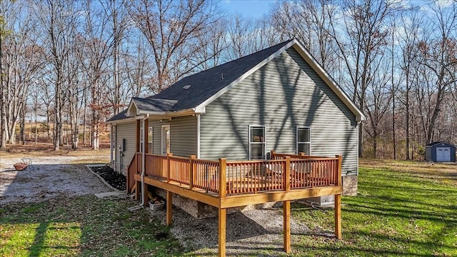 rear view of house with a lawn, a storage unit, and a deck