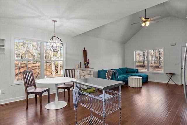 living room with a wealth of natural light, ceiling fan with notable chandelier, dark hardwood / wood-style floors, and high vaulted ceiling