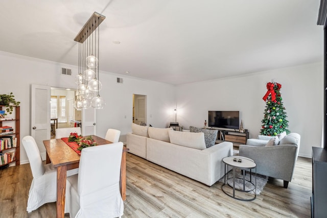 dining space featuring light wood-type flooring and ornamental molding